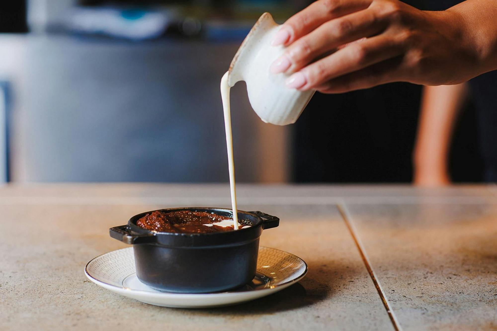 Stock Exchange Hotel, Manchester, Autograph Collection Bagian luar foto A pot of chocolate pudding being topped with cream